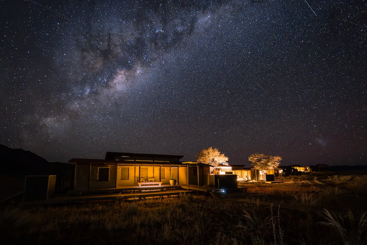 The Milky Way over the lit tents of Wolwedans Desert Lodge